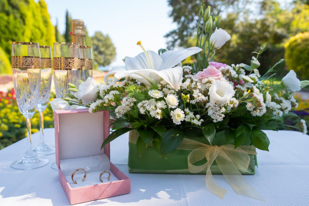 结婚戒指和杯子放在放花的桌子上图片下载