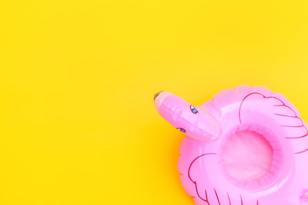 夏天海滩组成。简单的最小设计与粉红色充气火烈鸟孤立在黄色背景。泳池漂浮派对，时尚名流的时尚概念。平放俯视图拷贝空间图片下载