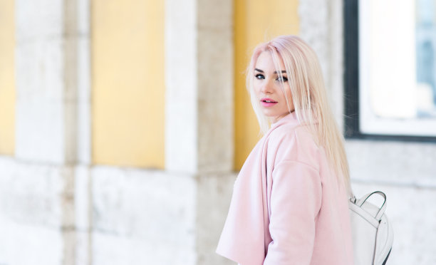 年轻女子背着背包走在欧洲的街道上图片下载