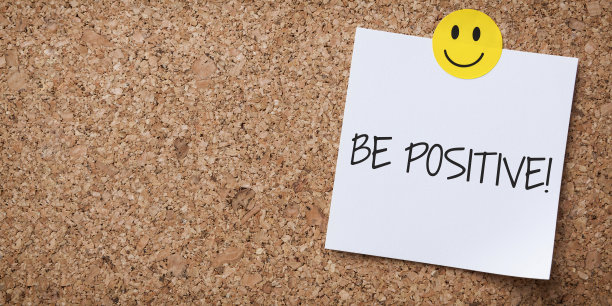 白色Sticky Note With Be Positive And Red Push Pin On软木板图片下载