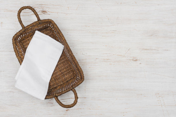 柳条篮子顶视图与白布上的木制背景图片下载