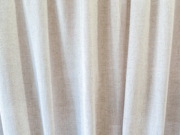 米色窗帘由天然亚麻布制成，有许多褶皱图片下载