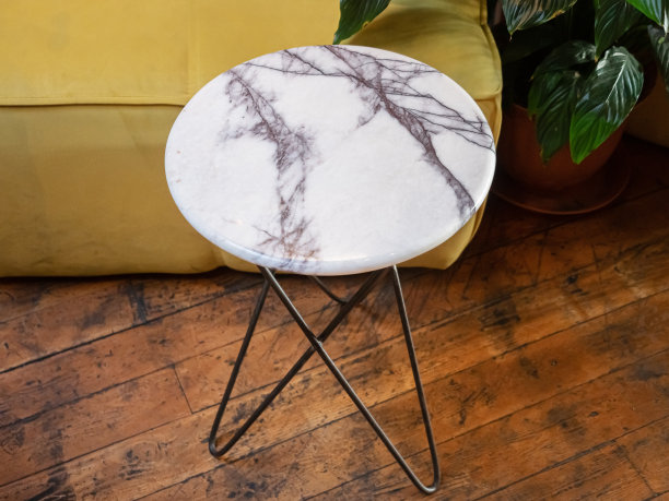一张带有大理石台面的咖啡桌的特写照片，旁边是木地板上的黄色蒲团图片下载