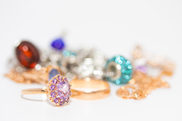 收藏珠宝与美丽的黄金戒指与紫色的石头孤立在白色的背景图片下载