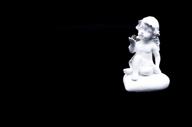 手持珍贵圆石的小白守护天使，黑色背景，情人节、新年、圣诞节装饰图片下载