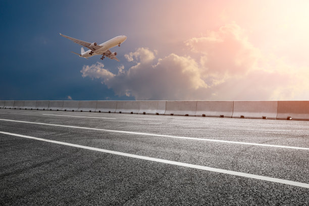 空旷的柏油路和日落时的天空飞机景观图片下载