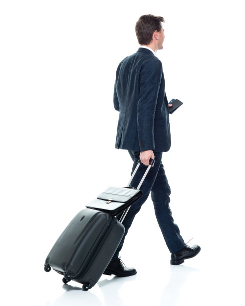 白人年轻男性商人穿着衬衫，提着行李箱走在白色背景前图片下载