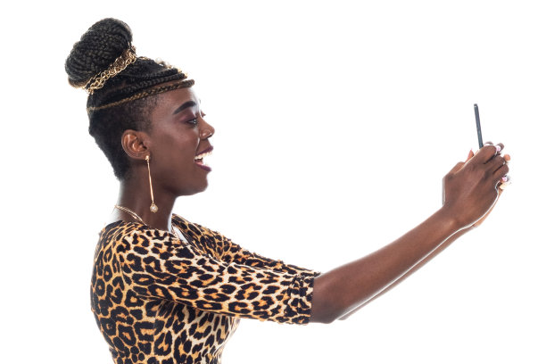 非裔美国女性穿着裙子使用智能手机站在白色背景前拍照图片下载