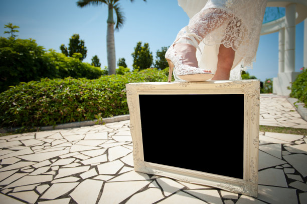 新娘踩在黑色背景的相框上图片下载