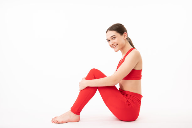 抱着双腿的迷人女孩，坐在白色背景上的年轻女孩照片，美容和身体护理概念图片下载