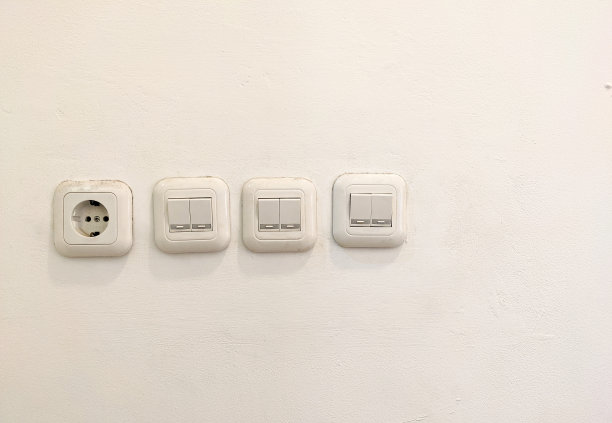 白色墙壁上的白色电灯开关图片下载