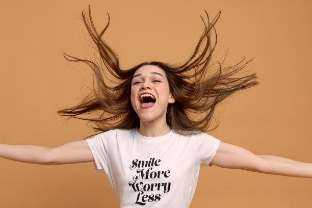 美丽的长发女孩穿着浅白色的t恤跳舞。室内照片漂亮的年轻女模特与跳跃在橙色的背景图片下载