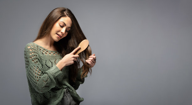 美丽的黑发女人梳头的肖像图片下载