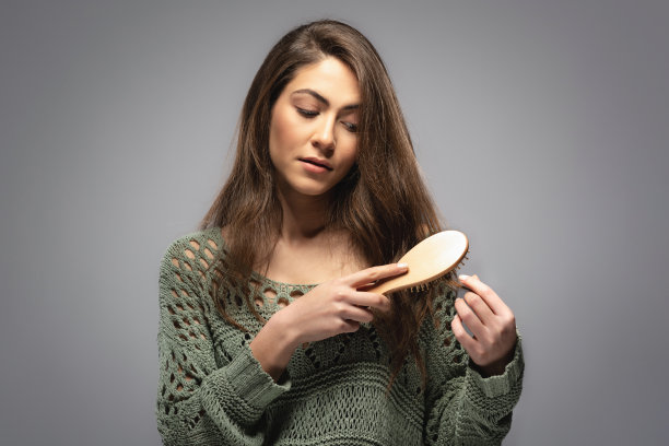 美丽的黑发女人梳头的肖像图片下载