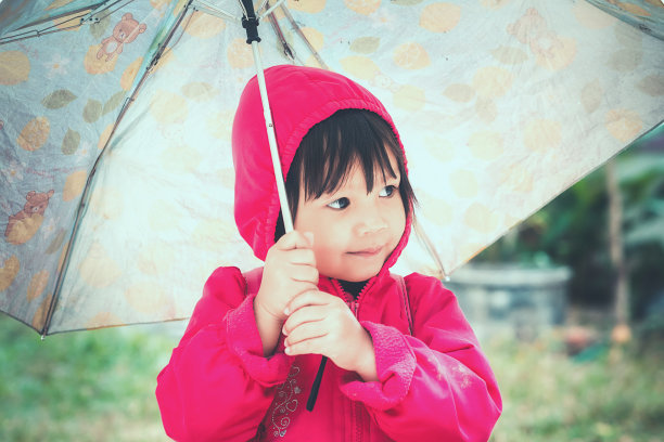 美丽的小女孩带着伞走过秋天的季节。图片下载