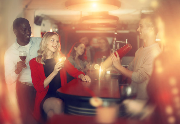 一对欢快微笑的男女在俱乐部的鸡尾酒派对上图片下载