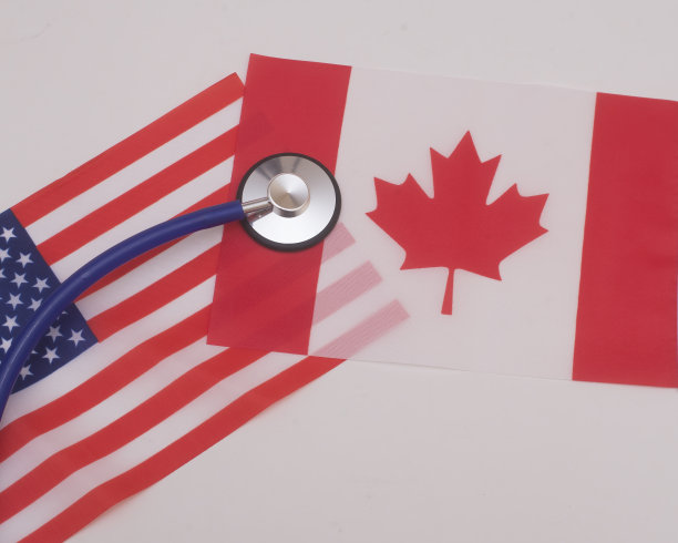 加拿大和美国国旗上的听诊器，显示两国在医疗保健方面的差异图片下载