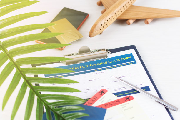 旅游保险理赔表，登机证和护照放在白色的木桌上。图片下载