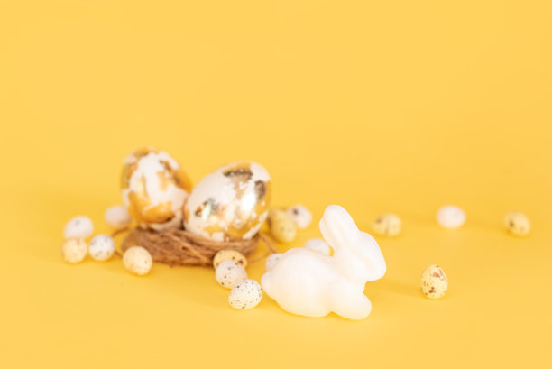 金色巧克力复活节彩蛋和巧克力兔子与复制空间在黄色的背景图片下载