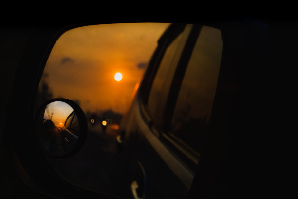 模糊的反射在侧面的汽车镜在日出图片下载