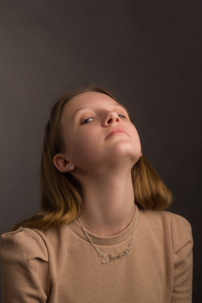 影棚棕色背景下的浅棕色T恤棕发模特肖像图片下载