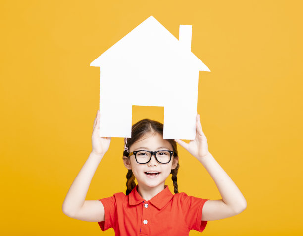快乐的小女孩展示和拿着房子模型图片下载