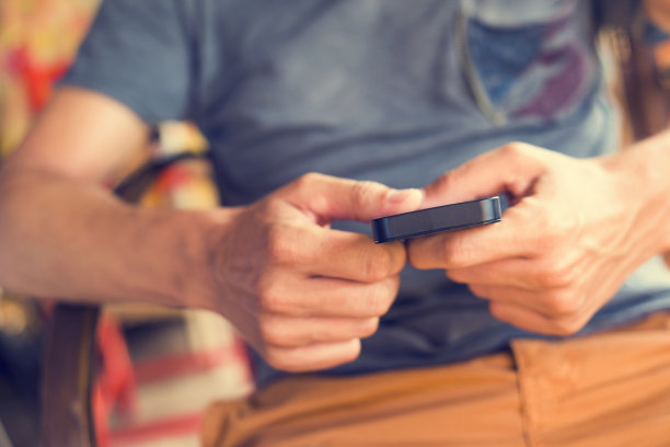 一个年轻人在乡下拿着智能手机图片下载