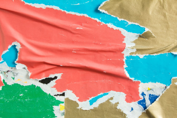 红色、金色、蓝色、绿色撕破、皱巴巴、剥落的布告纸在街头广告牌纹理背景上。图片下载