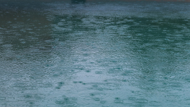 圆水滴在水圈上盘旋。水珠滴落、旋转、飞溅。水池纹理图案背景上的波纹。桌面或笔记本壁纸。近距离的水环影响着表面。图片下载