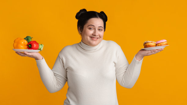 心态积极的丰满女人拿着装有甜甜圈和新鲜有机蔬菜的盘子图片下载