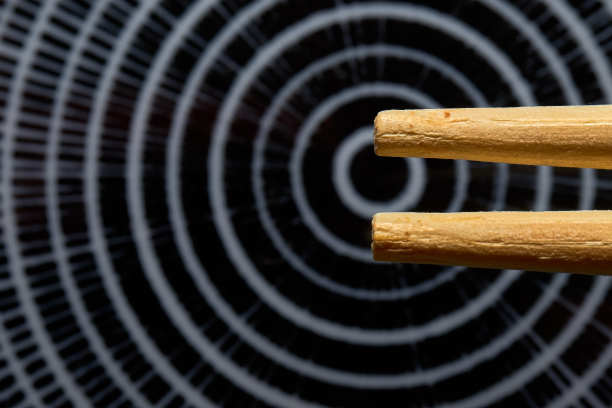 概念照片，微距从两根日本筷子的尖端在一个有意模糊的盘子与同心圆环图片下载