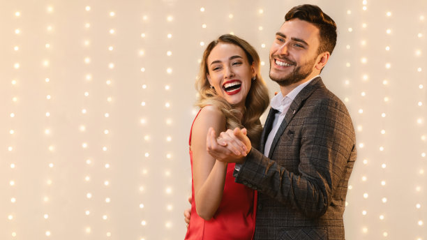 快乐的青年情侣跳舞，手牵着手，真诚地笑图片下载