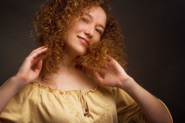 一个有着棕色卷发的女人的画室肖像图片下载