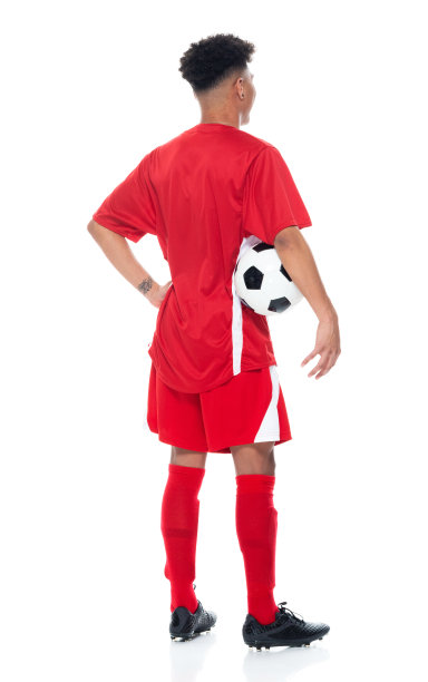 非洲裔少年运动员穿着足球制服站在白色背景前，拿着足球玩足球运动和使用运动球图片下载