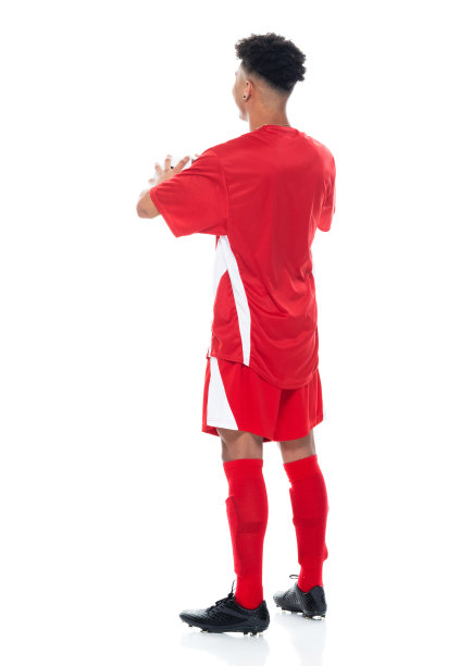 非洲裔少年运动员穿着足球制服站在白色背景前，拿着足球玩足球运动和使用运动球图片下载