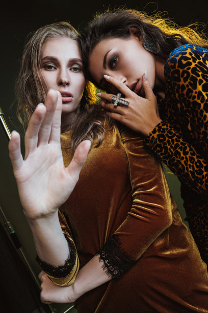 摄影棚里的时装摄影。漂亮的女人模型。黄色豹纹连衣裙。摄影架和闪光灯。黄色和绿色背景。图片下载