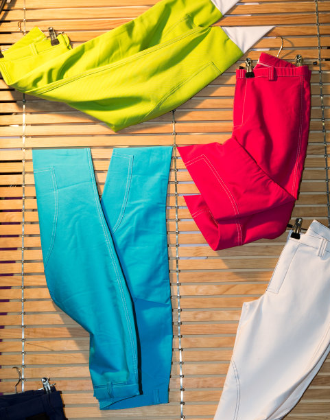 商店里挂在木制十字架上的彩色裤子图片下载