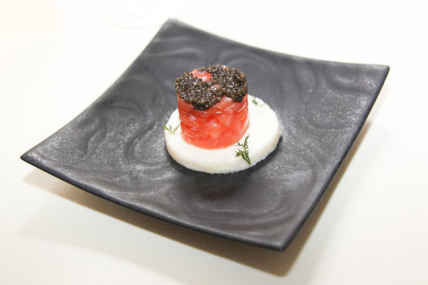 餐厅里的黑色盘子，上面有鲑鱼和鱼子酱图片下载