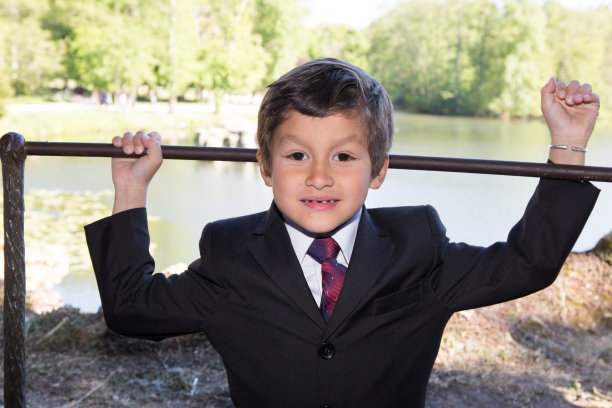 穿夹克打领带的小男孩在公园里图片下载