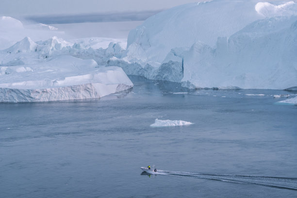 格陵兰岛伊卢利萨特冰峡湾的冰山和旅游渔船，巨型冰山景观，融化冰川形成的冰山，北极自然风貌的无人机航拍照片图片下载