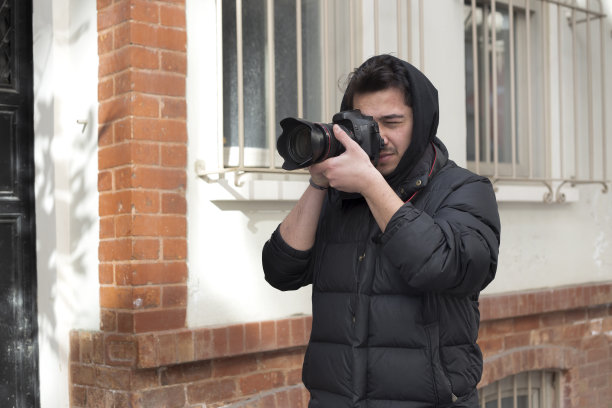 年轻的摄影师在城市的街道上拍照图片下载
