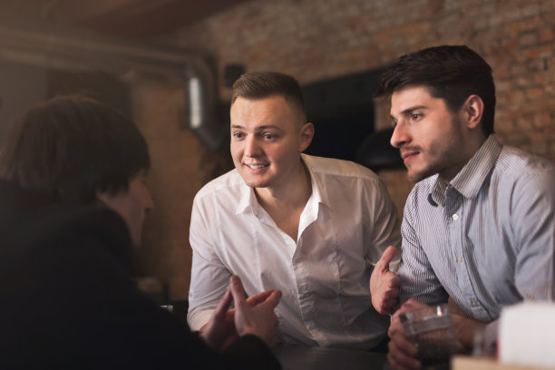 愉快的朋友在酒吧与调酒师交流图片下载