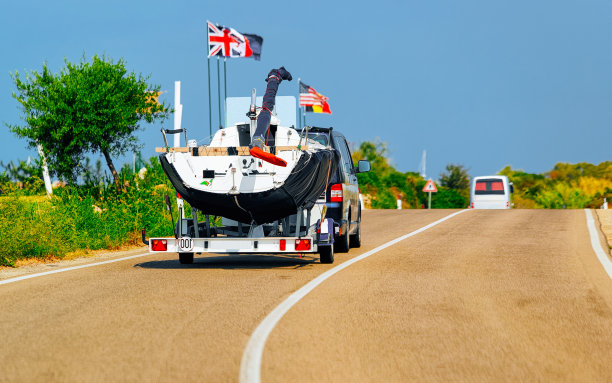 在撒丁岛道路上拖着游艇或摩托艇的汽车图片下载
