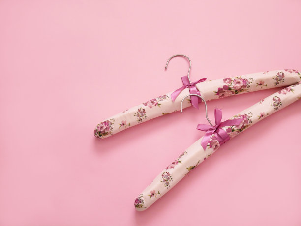 淡粉色背景的衣架上有拷贝空间。图片下载