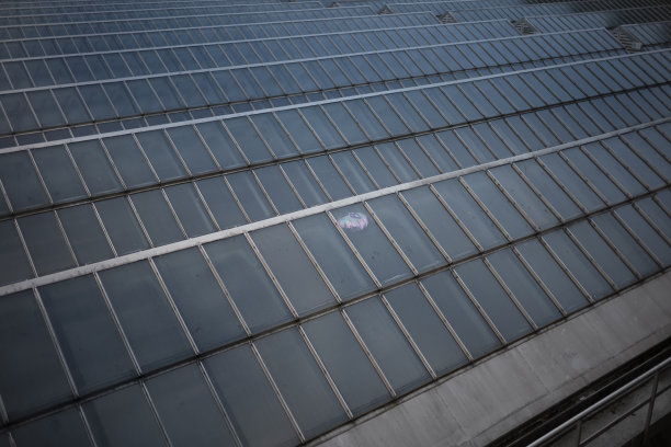 一个装满氦气的气球漂浮在欧洲一个大城市的火车站的玻璃天花板上。图片下载