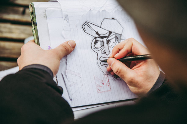 年轻的涂鸦艺术家在城市街道上素描图片下载