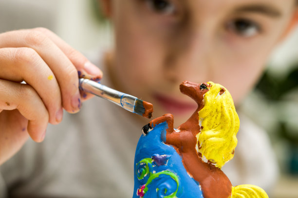 女孩正在仔细地画一件泥马陶器素材图片