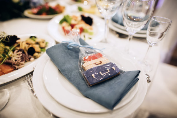 在餐厅里，客人的礼物是放在盘子里的饼干。婚礼的想法图片下载