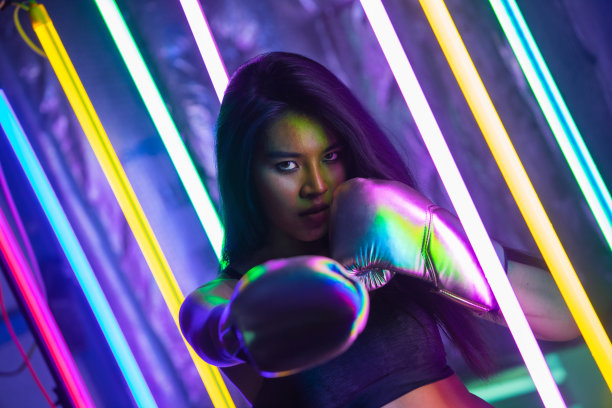 戴着拳击手套在泰拳馆锻炼的年轻女子图片下载