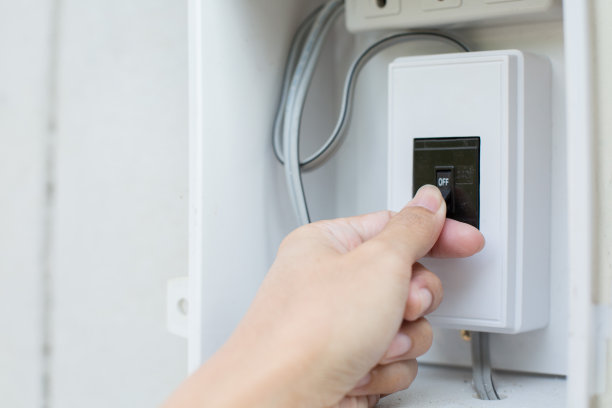 手握着旧的断路器开关图片下载